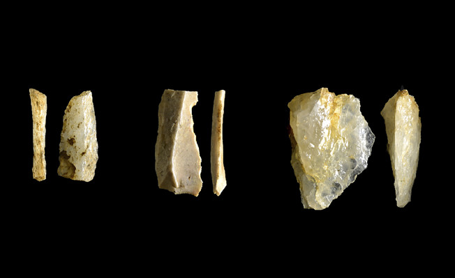 Skärande redskap tillverkade i kvarts (till vänster och höger) och i flinta (i mitten). Foto: Arkeologerna, SHM