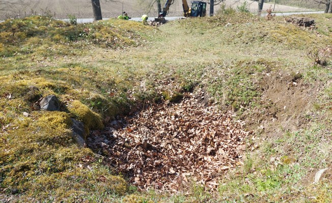 En av de många plundringsgroparna i gravhögarna vid Bönsta. FOTO: Trafikverket.